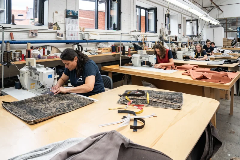 Een stikster naait de gesneden delen samen aan de machine